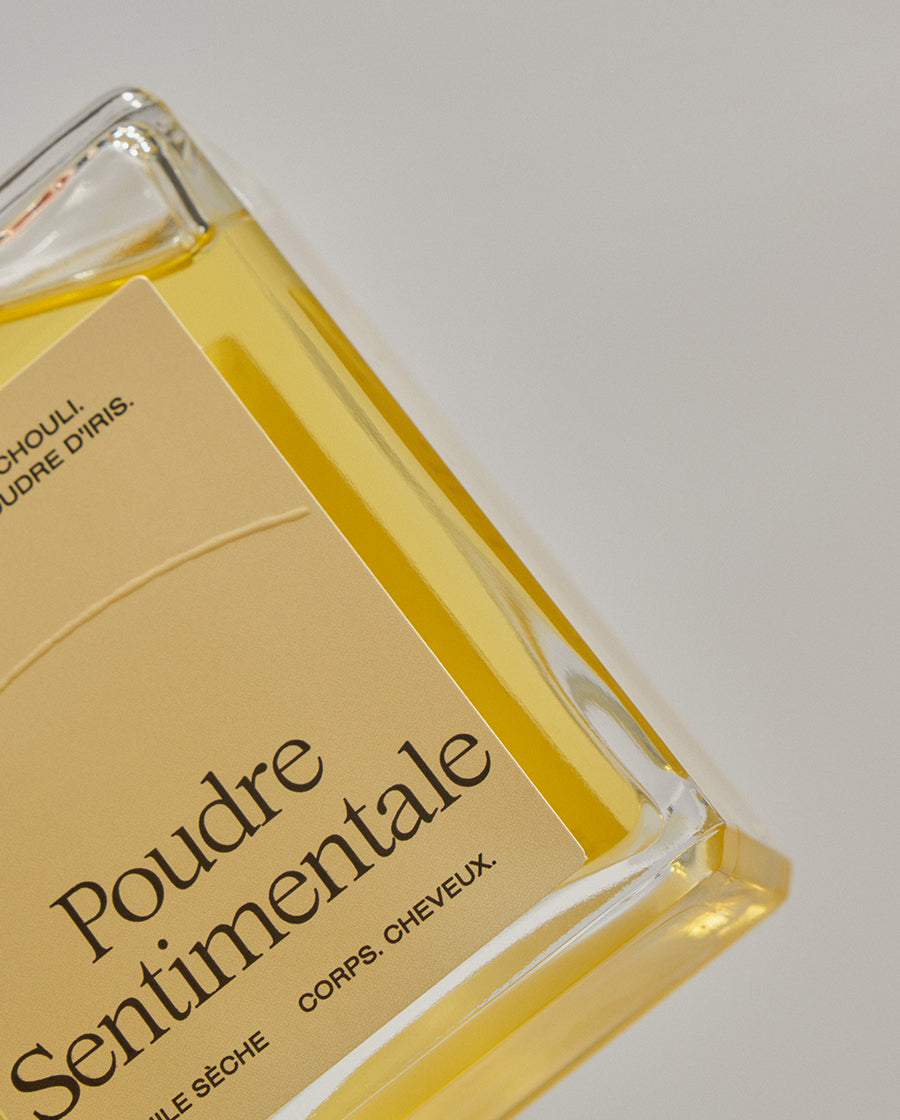 Gros plan sur la flacon de l'huile sèche parfumée Poudre Sentimentale de chez Refeel Naturals